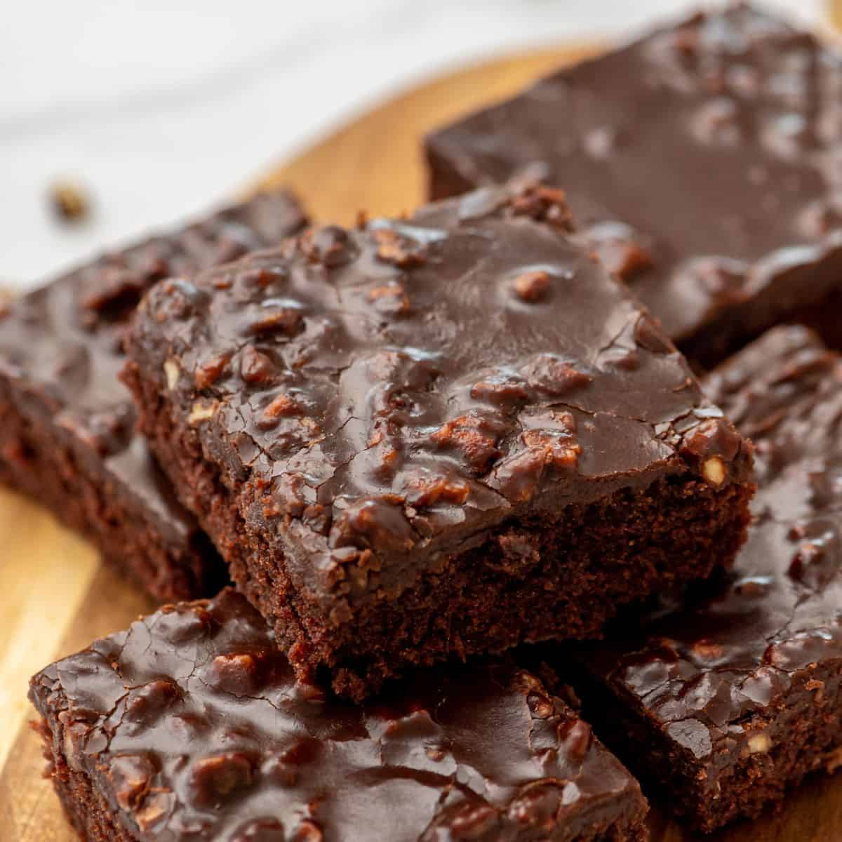 Super Bowl Party Recipes Sliced Texas Sheet cake with pecans on wooden cutting board.