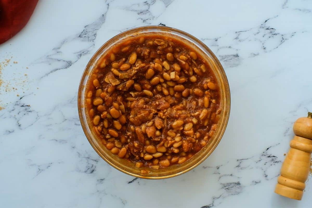 Cooked beans in baked bean sauce with molasses, brown sugar, and bacon.