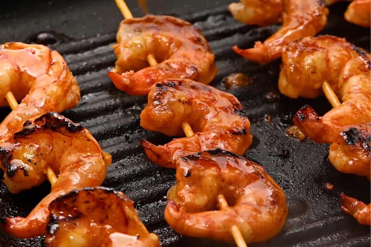 Shrimp Skewers on grill pan glazed in garlic marinade.