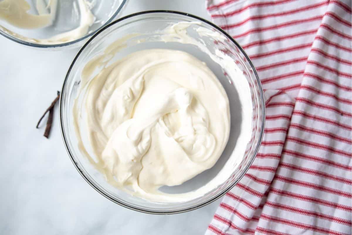 Large mixing bowl with whipped cream folded into sweetened condensed milk. 