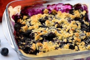 Blueberry Pie Bars baked in glass 8x8 baking dish with shortbread crumble.