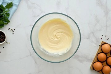 Hellmann's mayonnaise mixed with vinegar and salt in large mixing bowl.