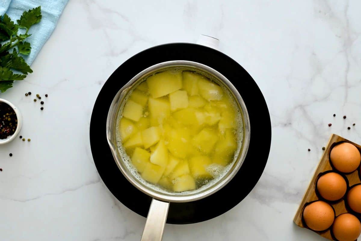 Peeled diced potatoes in a saucepan covered with water.