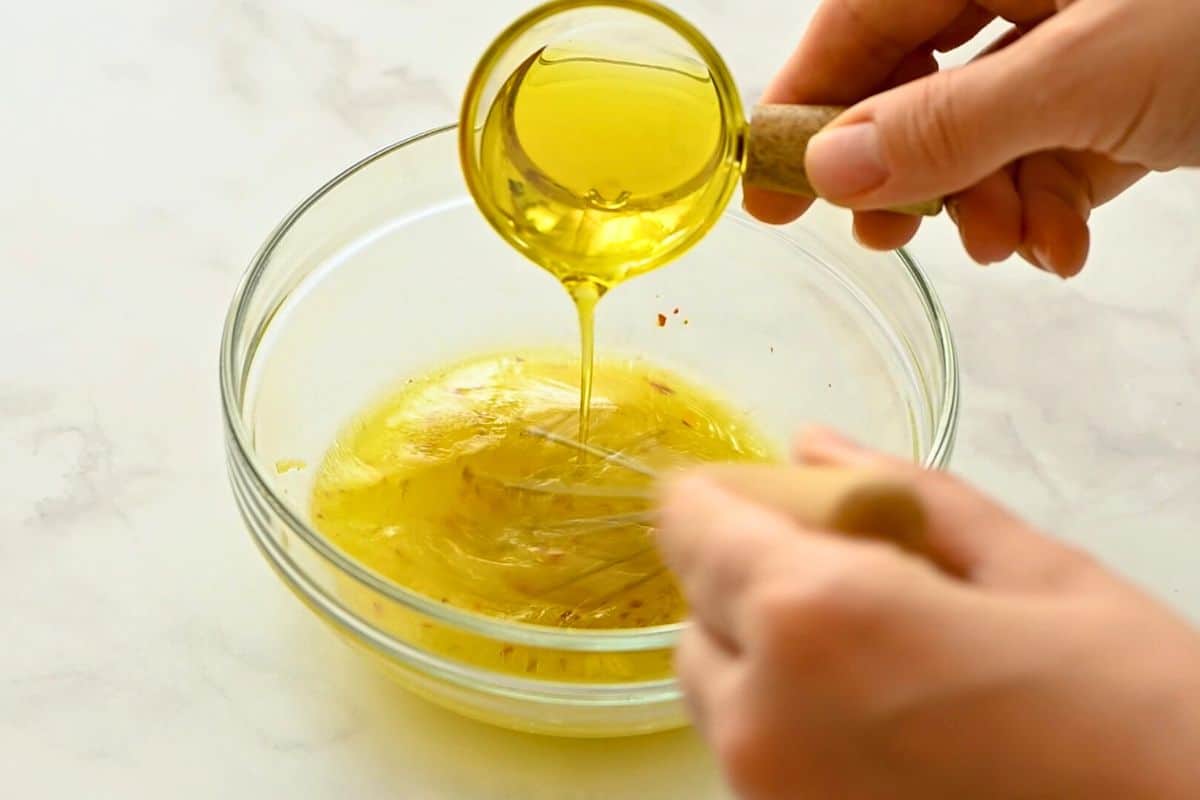 Olive Oil being emulsified into dressing for greek salad.