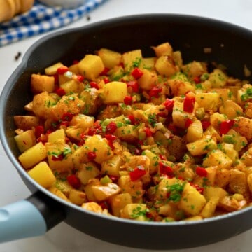 Potatoes Obrien in skillet topped with parsley.