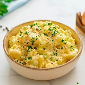 Hellmann's Potato Salad dished in large bowl topped with crushed pepper and parsley.