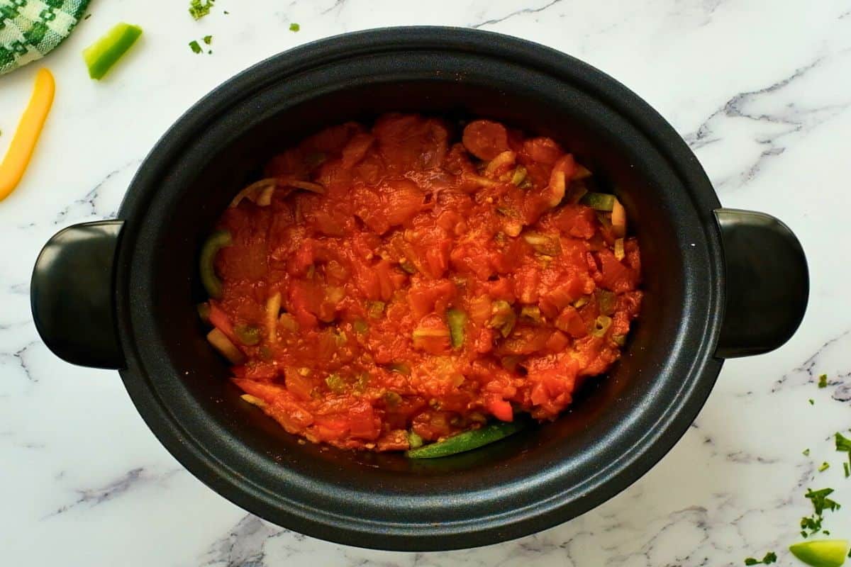 Steak and pepper mixture topped with Rotel tomatoes in crockpot.