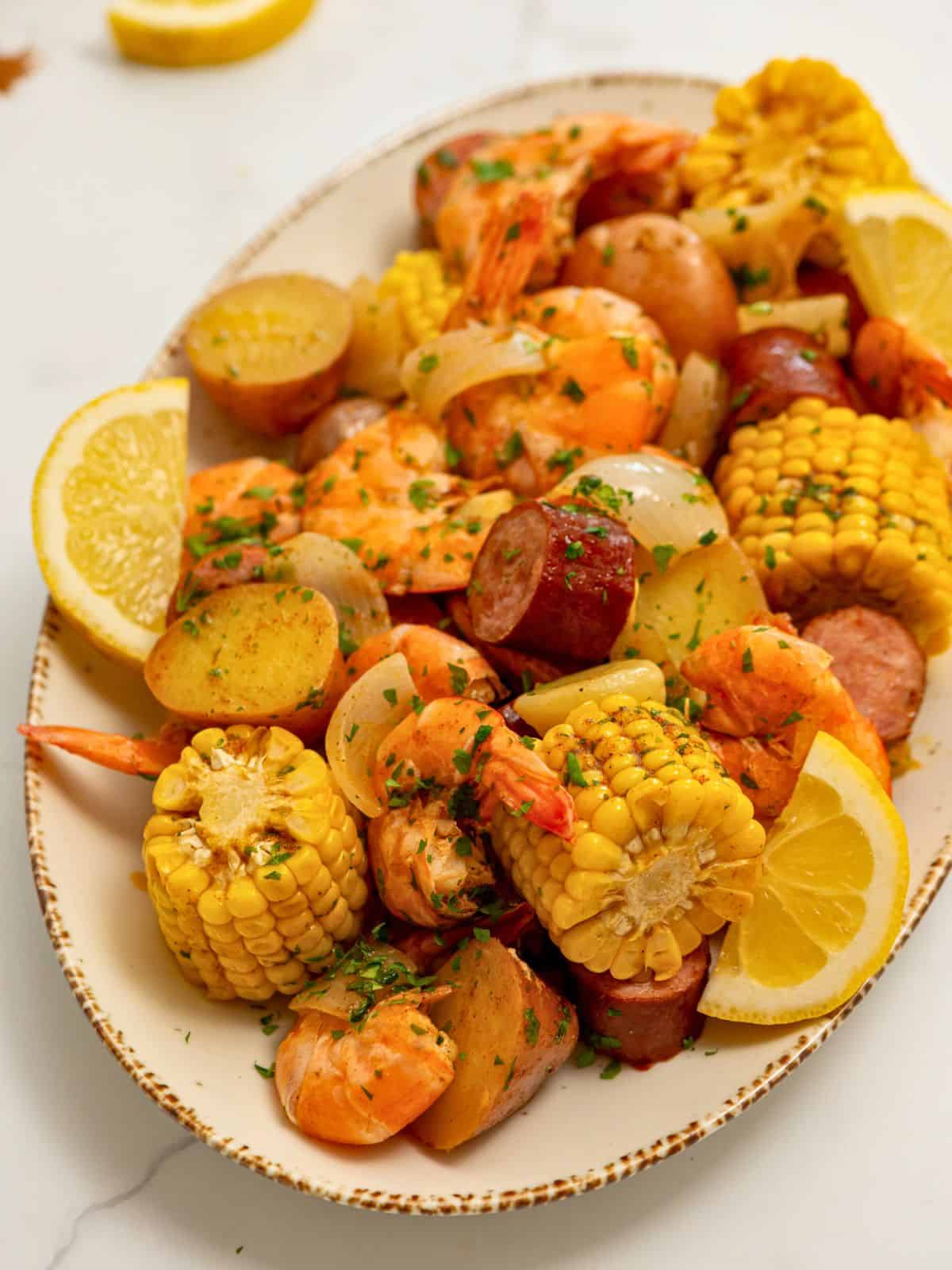 Shrimp Boil served on platter with lemon wedges, parsley, and melted butter.