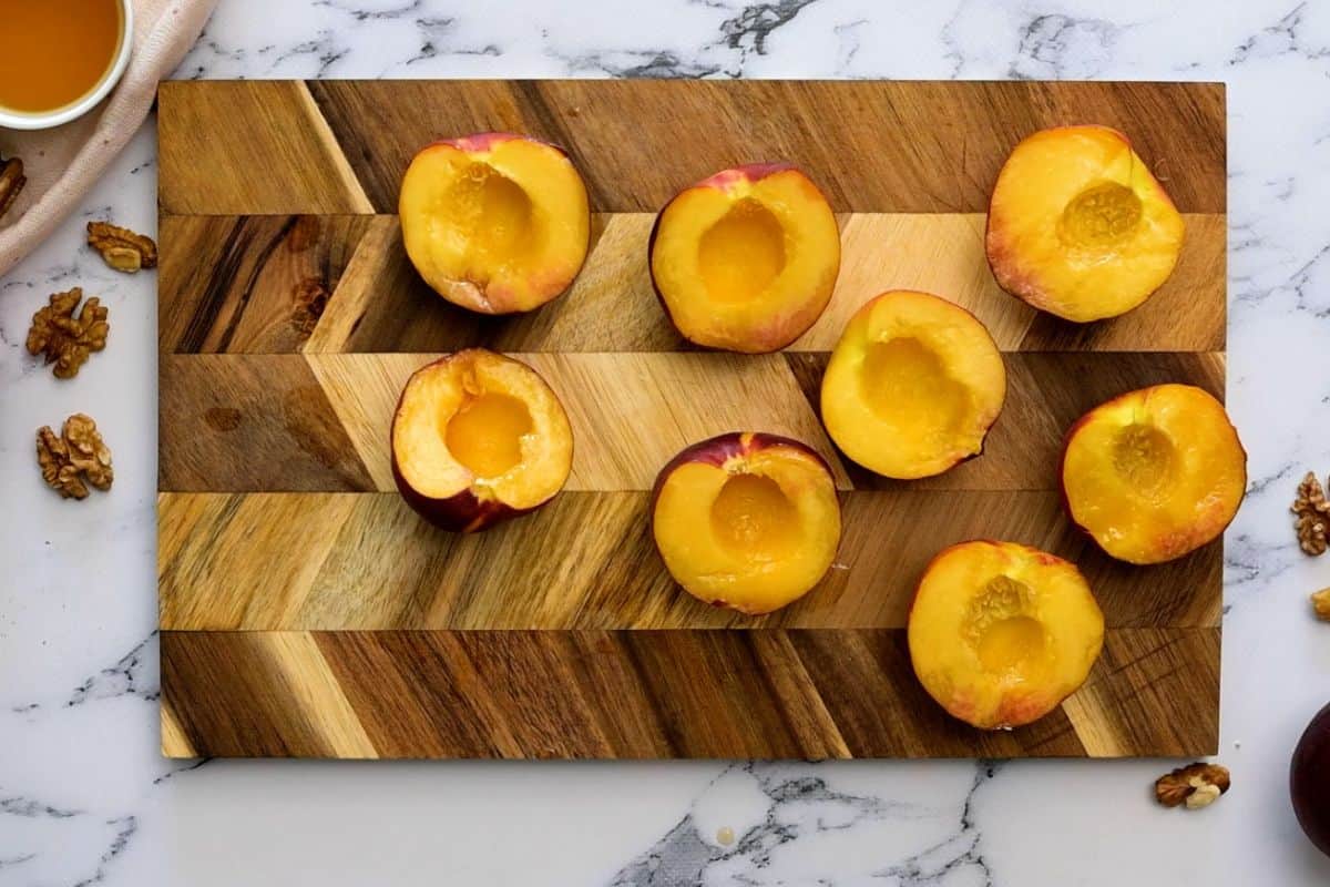 Sliced peaches on wooden cutting board.