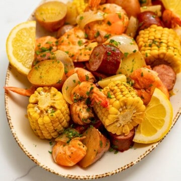 Shrimp Boil after being drained off served on platter with lemon wedges, butter and parsley.