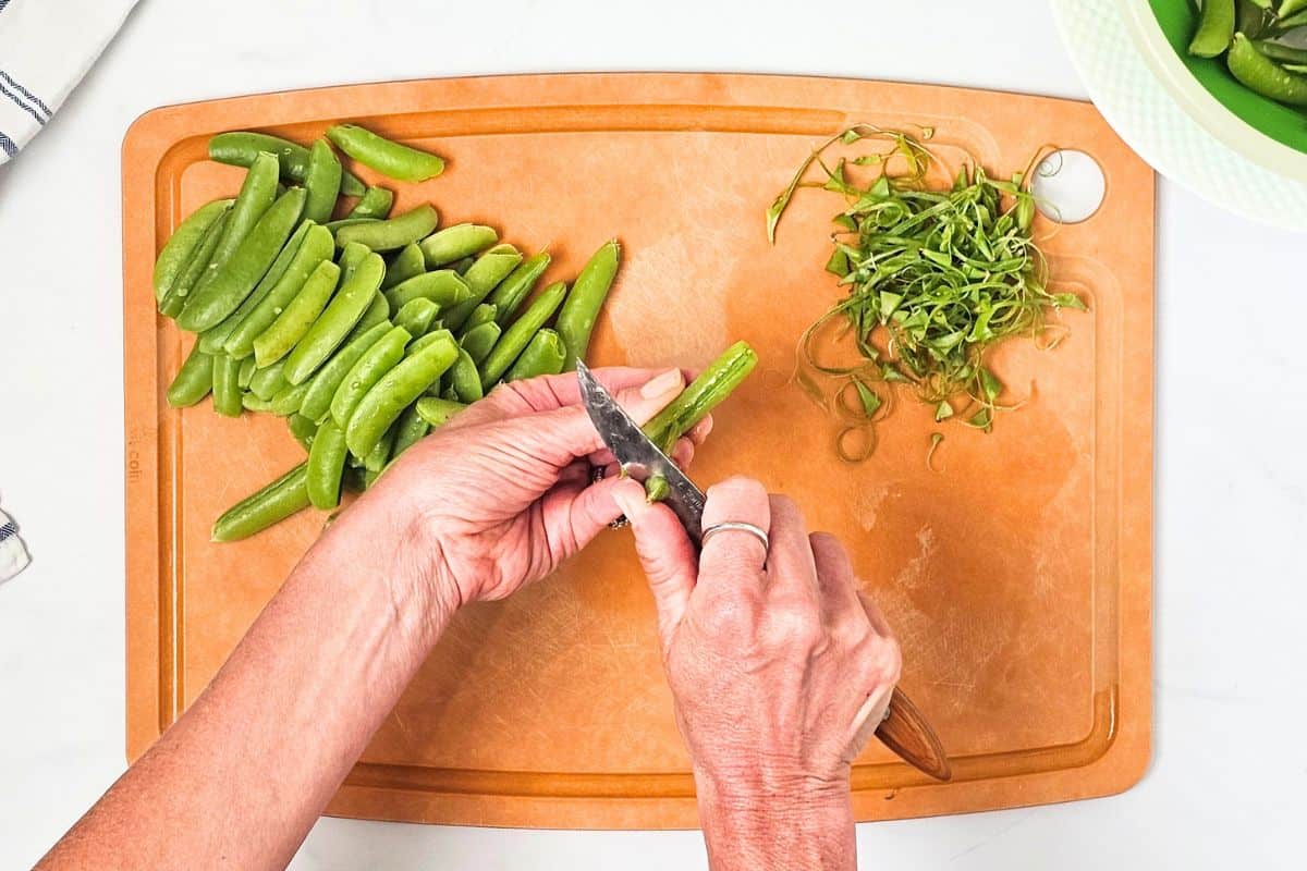 Best Sugar Snap Pea Recipe Pairing knife removing string from sugar snap peas before sauteeing.