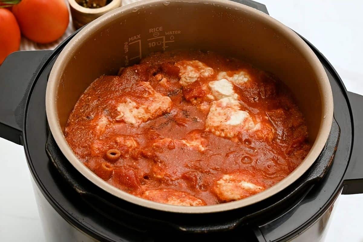 Instant Pot filled with ziti, tomato sauce, and ricotta all pressure cooked together before being stirred together.
