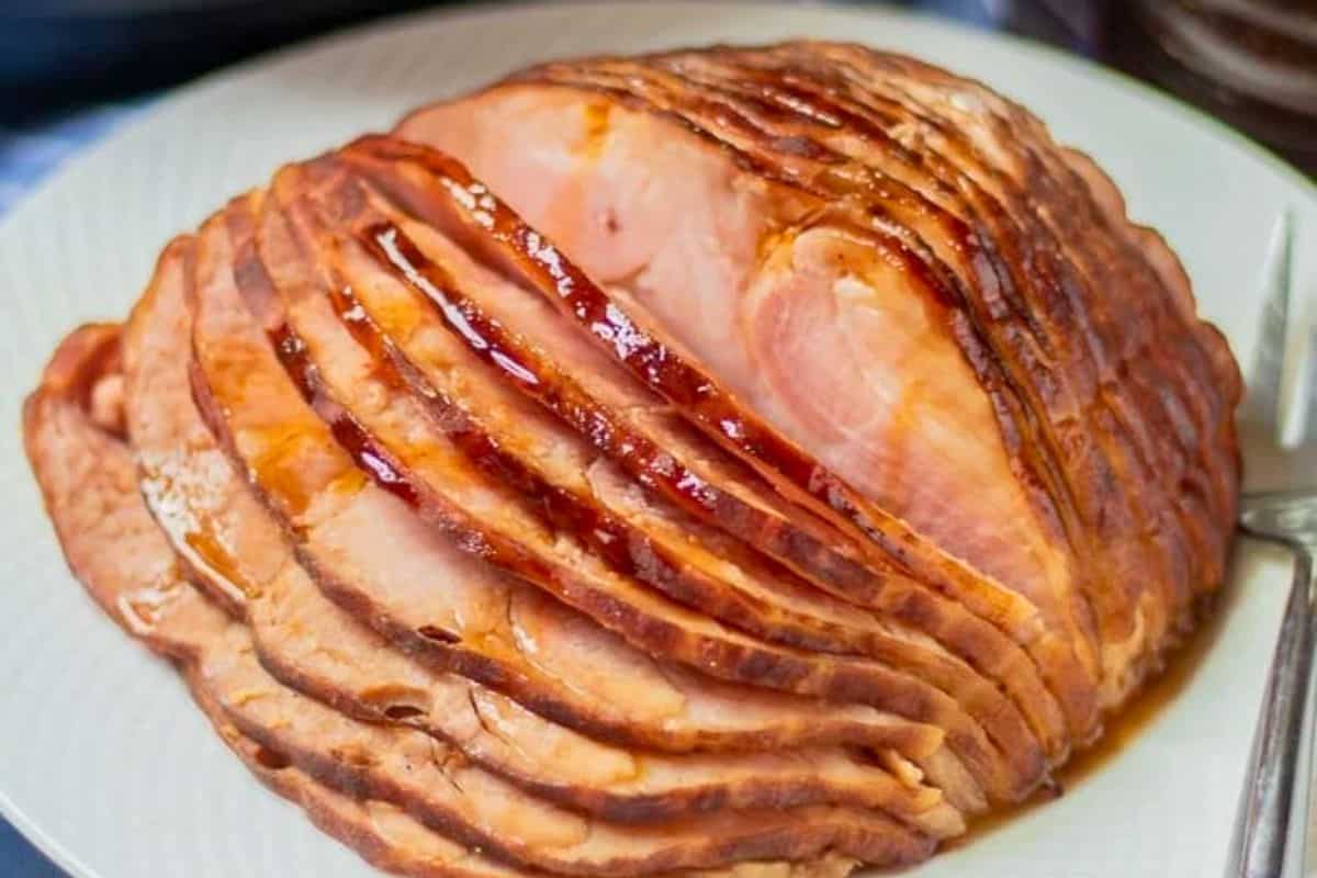 Easter Dinner Recipes Sliced Instant Pot ham on white platter glazed with honey and pineapple juice.