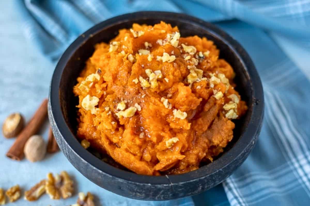 Easy Instant Pot Recipes for Thanksgiving Bowl of Instant Pot Mashed Sweet Potatoes topped with maple syrup topped with walnuts.