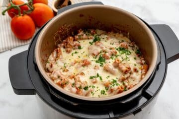 Pasta with tomato sauce, ricotta, and cheese pressure cooked together inside Instant Pot topped with parsley.