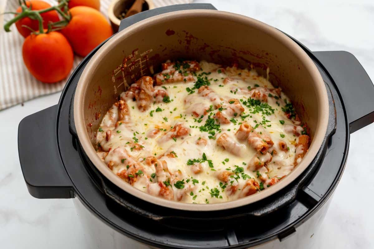 Pasta with tomato sauce, ricotta, and cheese pressure cooked together inside Instant Pot topped with parsley.
