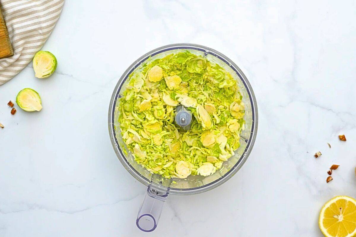 Salad with Shaved Brussel Sprouts Food Processor with shaved brussels sprouts inside.