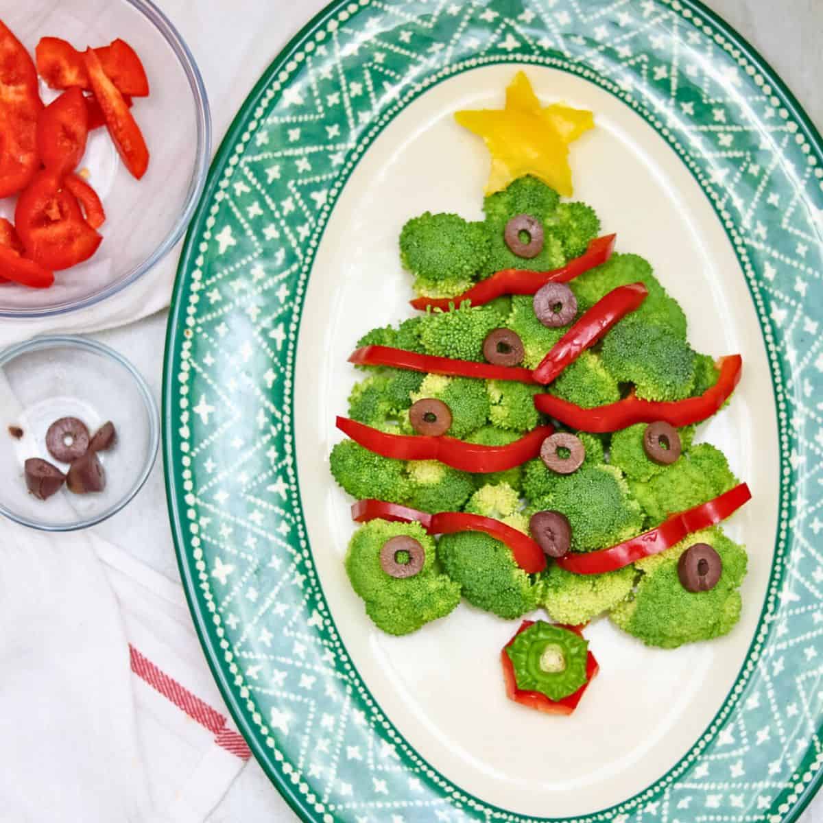 Easy Christmas Appetizers Christmas tree made with raw broccoli florets, red peppers, and black olive ornaments.