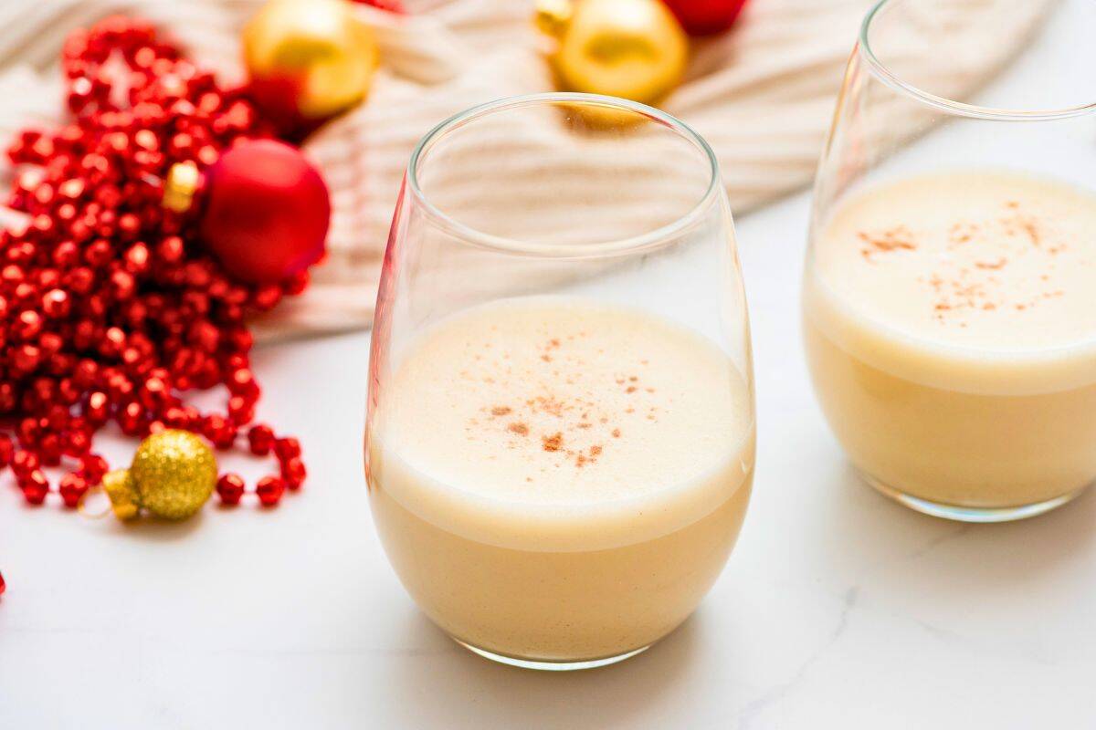 Eggnog Recipe with Coconut Milk 2 glasses of homemade eggnog made with coconut milk and nutmeg next to Christmas ornaments.