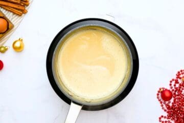 Thick and creamy homemade eggnog in small saucepan made with coconut milk and egg yolks.