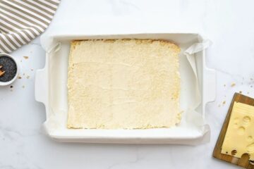 Split bottom half of Hawaiian rolls covered with thin layer of mayo in baking dish lined with parchment paper.