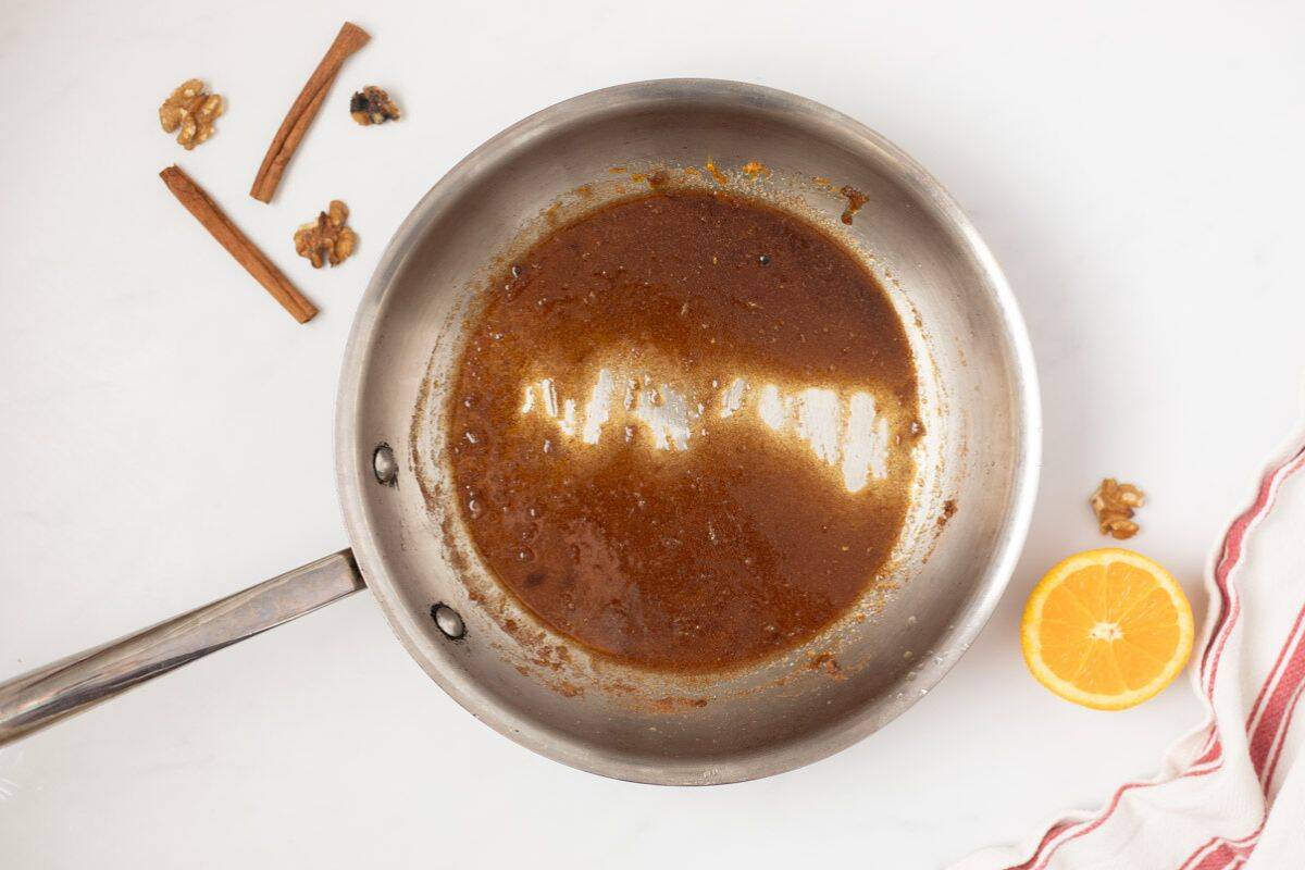 Orange juice, orange zest, brown sugar, white sugar, cinnamon, salt, and cayenne whisked together in stainless steel skillet.