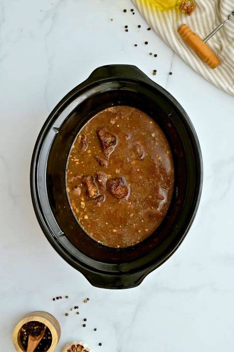Beef Tips with Gravy Seared beef, reduced wine, seasonings and beef stock layered in crock pot before slow cooking.