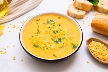 Bowl of Italian Pastina soup served with a drizzle of olive oil, fresh minced parsley, and parmesan cheese.