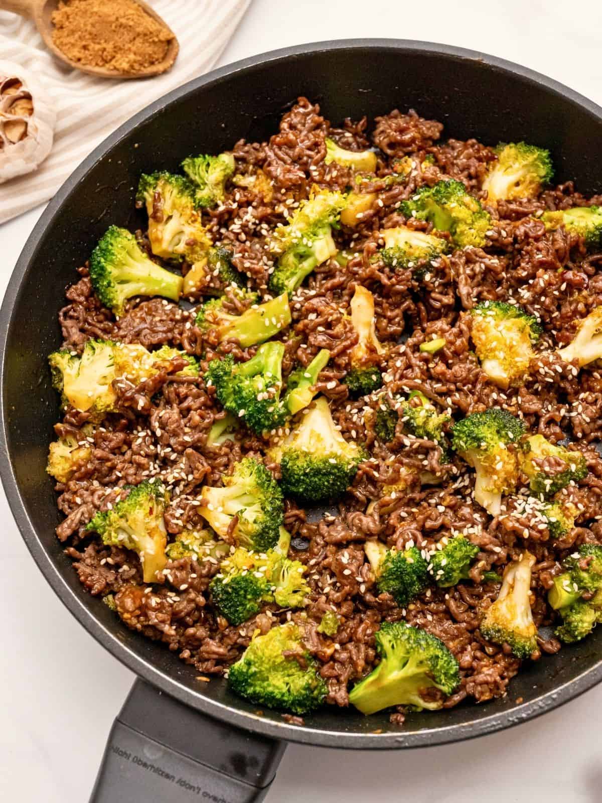 Ground Beef and Broccoli Sautéed ground beef with crisp tender broccoli tossed with sweet and savory sauce in sauté pan topped with sesame seeds.