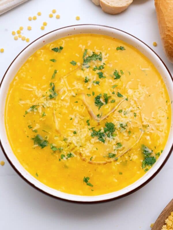 Bowl of Italian Pastina soup served with a drizzle of olive oil, fresh minced parsley, and parmesan cheese.