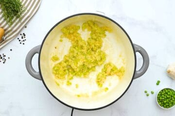 Onions, celery, and garlic sauteed in large soup with flour whisked into soup pot to form roux to thicken chicken pot pie soup.