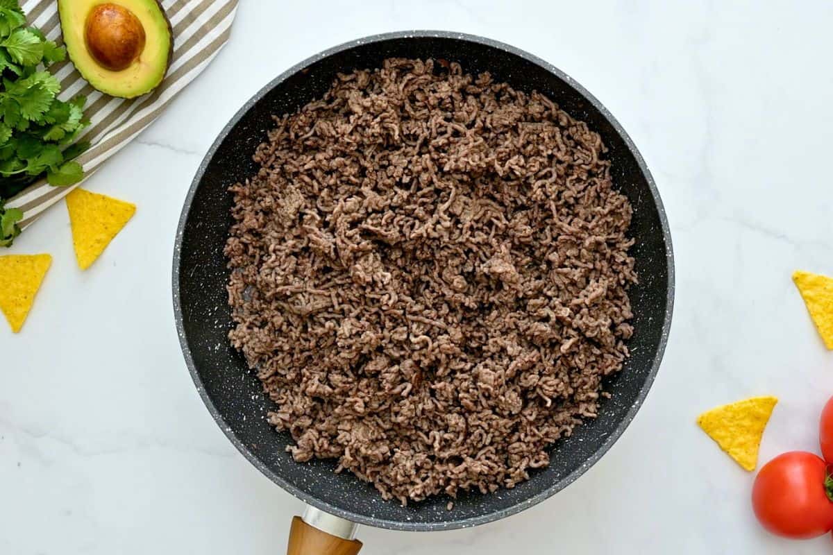 Taco Bake Recipe Cooked and crumbled ground beef in skillet for base of taco casserole.