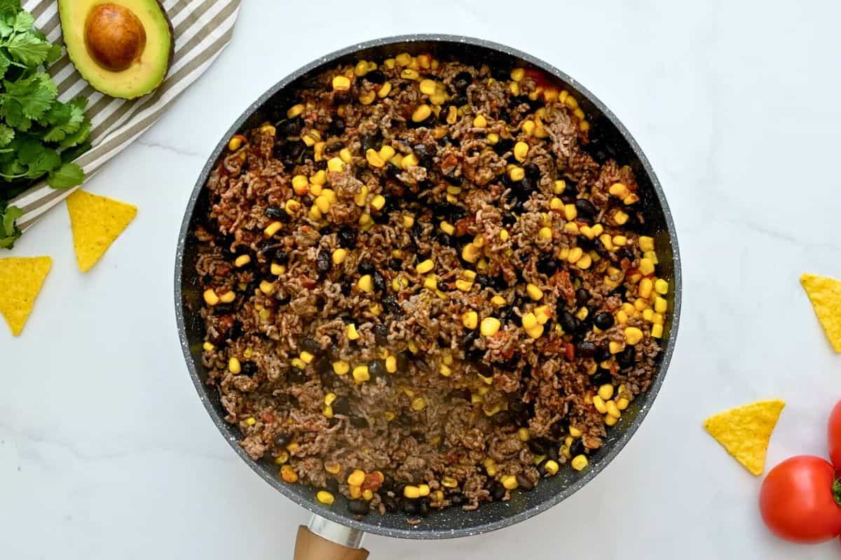 Mexican Taco Bake Casserole Ground beef, beans, and corn in large skillet seasoned with tomato sauce and taco seasoning to form base