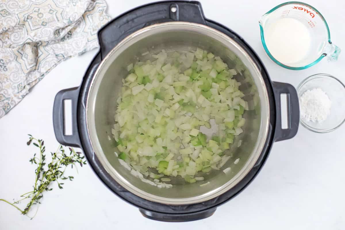 Vegetarian Wild Rice Soup Softened diced yellow onions and celery inside inner pot of Instant Pot for base of Instant Pot Wild Rice Soup.