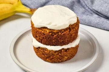 Two-layer dog birthday cake with oats, peanut butter, banana, and pumpkin, topped with Greek yogurt frosting.