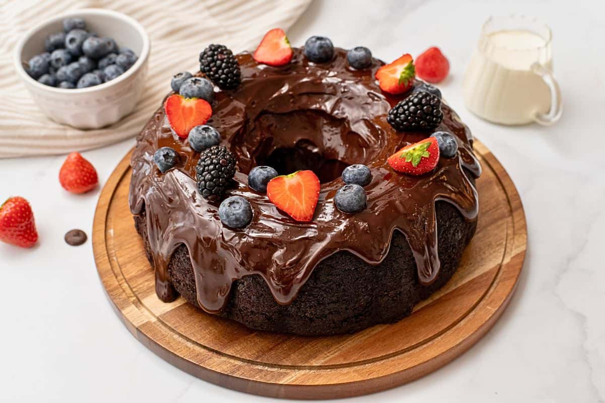Sour Cream Chocolate Bundt Cake Recipe Chocolate bundt cake with chocolate ganache icing and berries on top.
