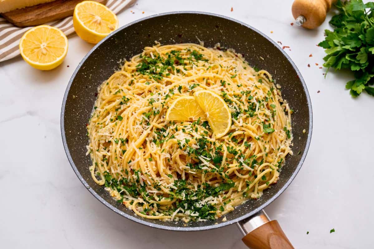 Garlic Lemon Pasta Pasta tossed with lemon, garlic butter, and parmesan in skillet topped with lemon slices and fresh minced parsley.