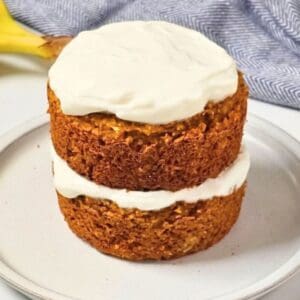 Two-layer dog birthday cake with oats, peanut butter, banana, and pumpkin, topped with Greek yogurt frosting.
