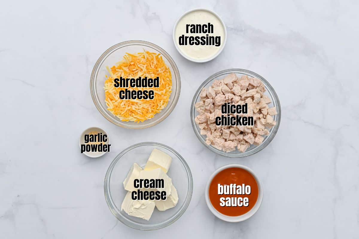 Buffalo Chicken Wing Dip Recipe Cubed cream cheese, ranch dressing, shredded cheese, garlic powder, hot wing sauce, and diced chicken in bowls with text labels.