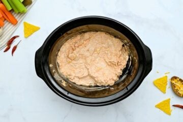 Cubed cream cheese, ranch dressing, shredded cheese, garlic powder, hot wing sauce, and diced chicken mixed together inside liner or crockpot.
