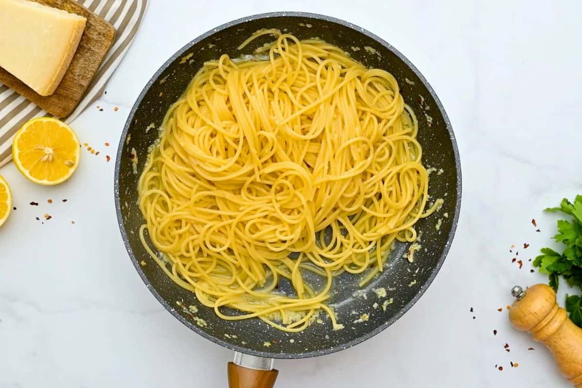 Easy Garlic Lemon Spaghetti Cooked spaghetti tossed with garlic butter in skillet.