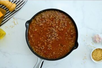 Deep skillet with taco meat, salsa, beef broth.