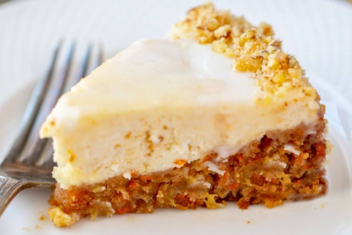 Dinner Recipes for Entertaining at Easter Slice of Instant Pot Carrot Cake Cheesecake on white plate showing layers of carrot cake and cheesecake.