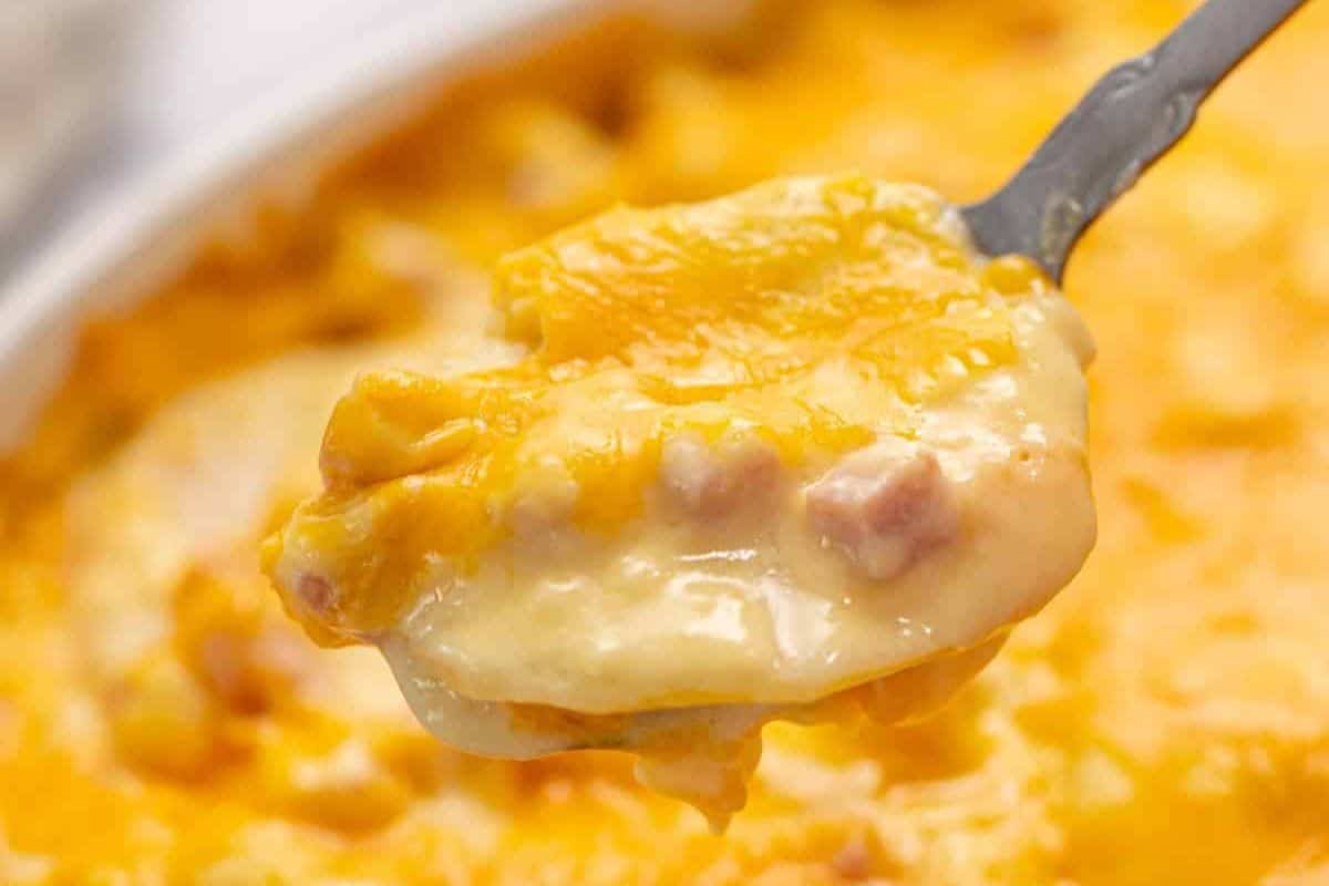 Ideas for Easter Dinner Menu Scoop of cheesy scalloped potatoes with ham.