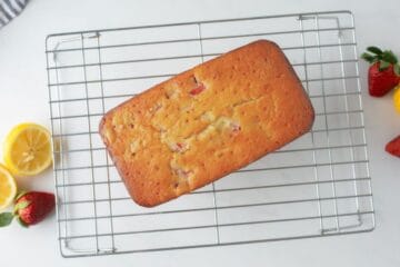 Strawberry loaf on wire rack cooling after being baked and glazed.