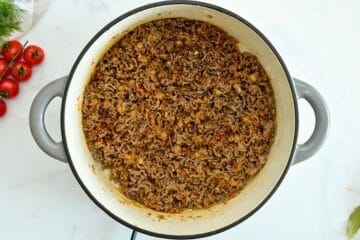Browned ground beef with paprika, onion powder, diced onion, and garlic cooked together in large Dutch oven for base of unstuffed cabbage rolls.