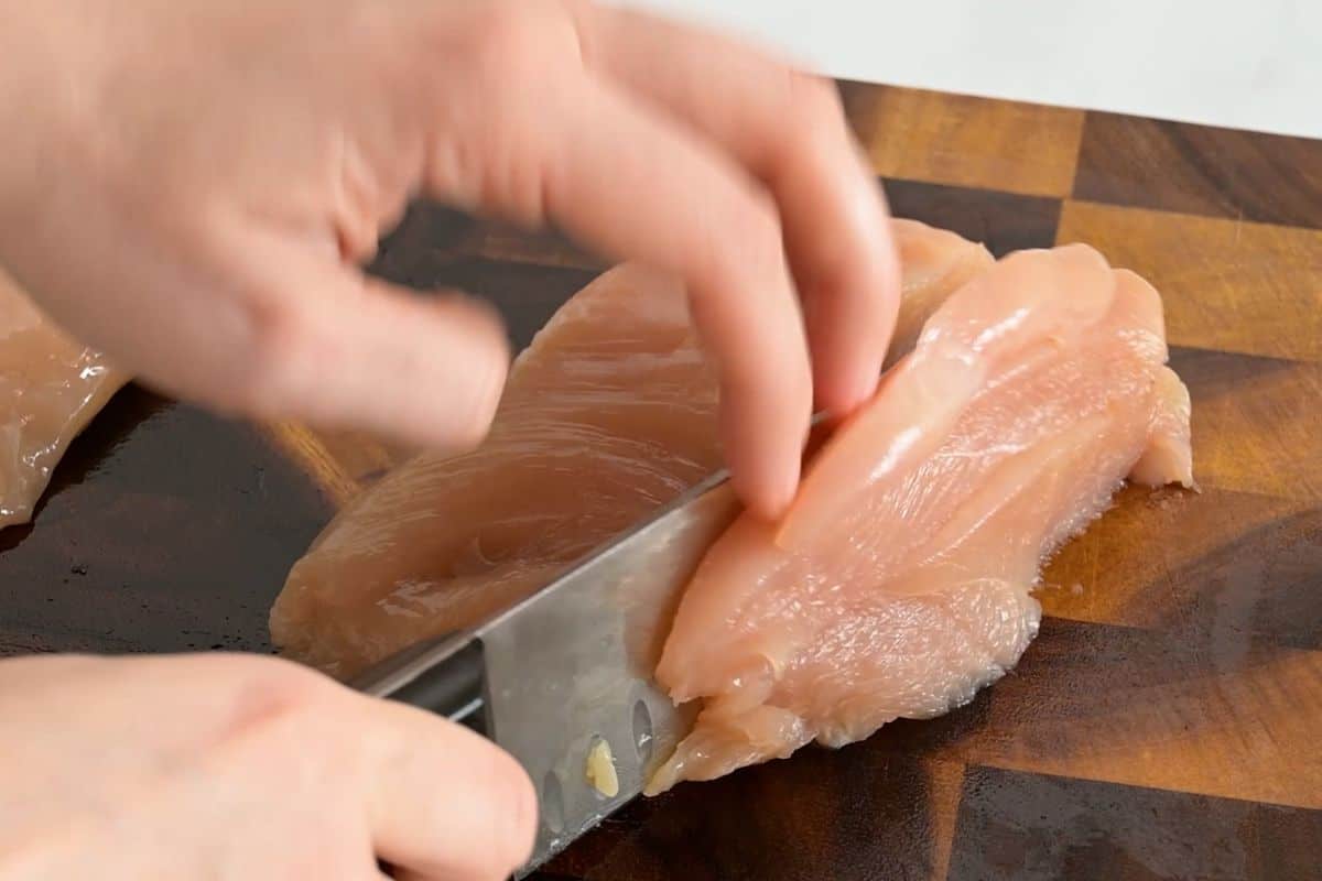 Easy Fajita Recipe with Chicken Thinly slicing chicken breasts into ½-inch strips against the grain for sheet pan chicken fajitas.