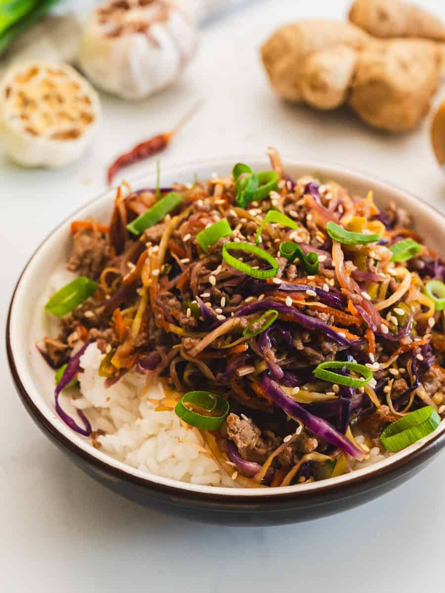 Browned turkey with coleslaw mix and egg roll sauce served over steamed white rice with sesame seeds and green onions.