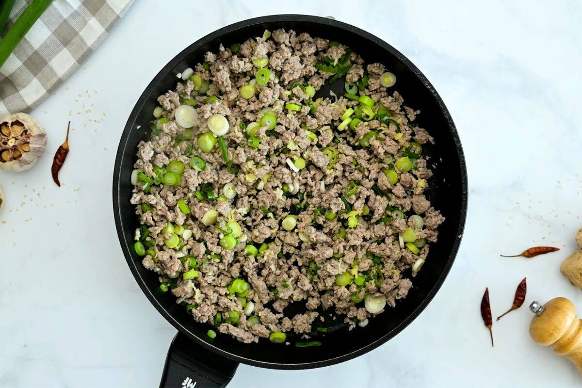 Egg Roll Bowl Recipe Browned ground turkey with green onions in skillet for base of egg roll in bowl.