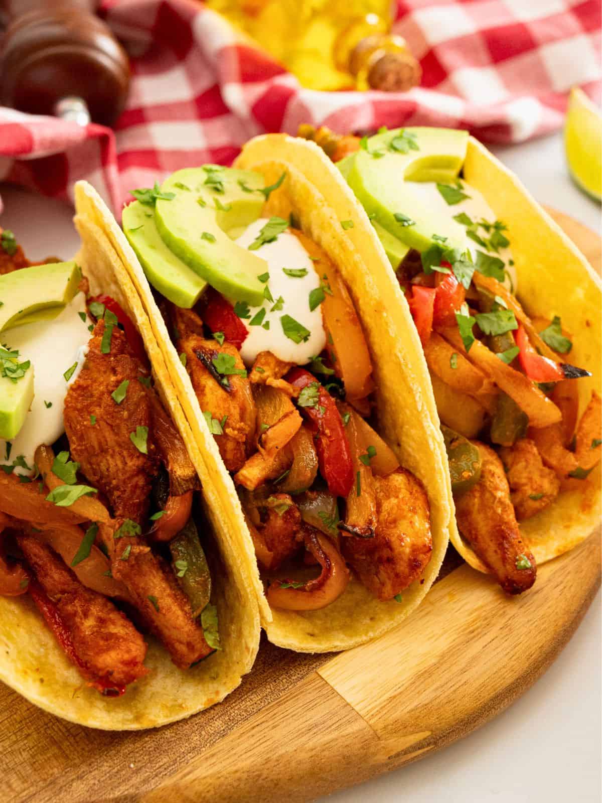 Fajitas with Chicken and Peppers Roasted chicken, peppers and onions served in tortillas with sour cream and avocado and minced cilantro.